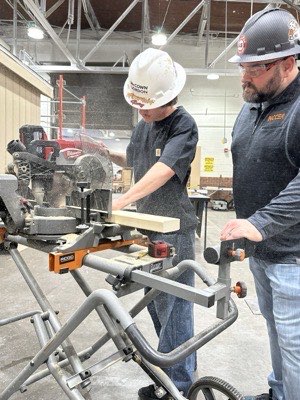 Teacher Aaron Haselwood with a student in his Wichita school shop