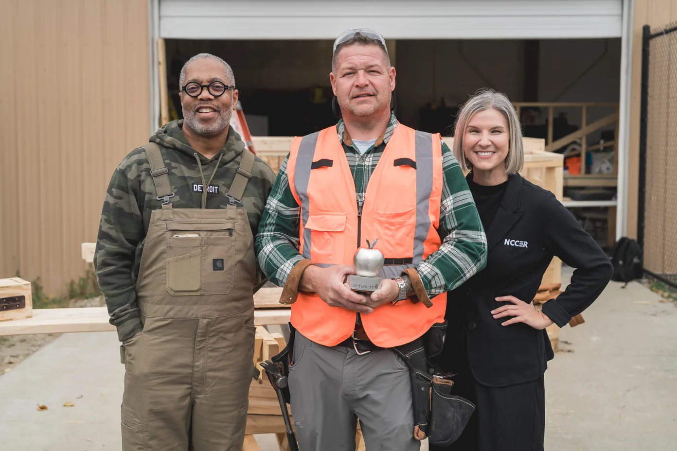 Aaron Swett receiving the Steel Apple Award from Todd Corley, Chief People & Impact Officer at Carhartt, and Stephanie Watts, Director of Philanthropy at NCCER