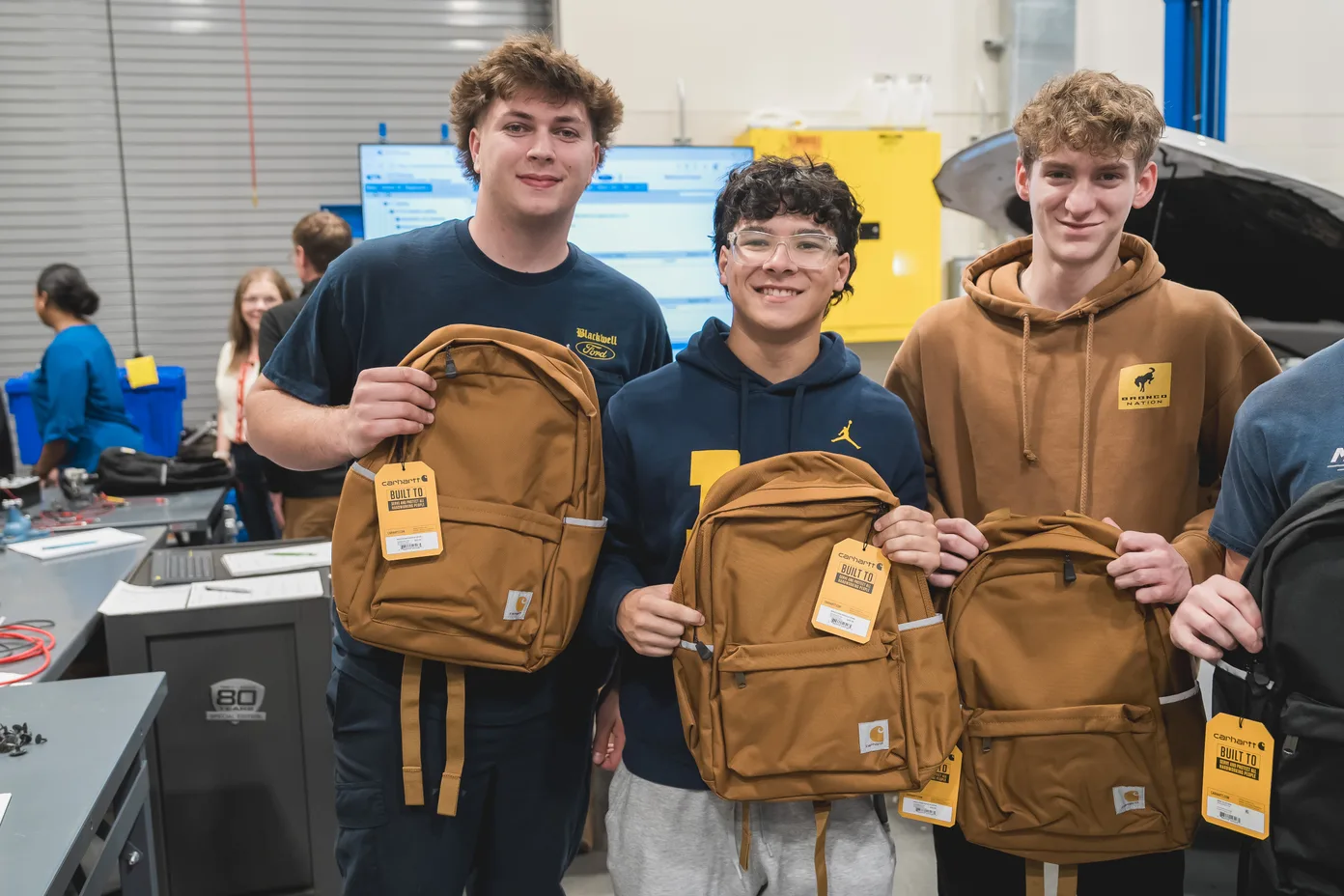Henry Ford College students celebrate receiving Carhartt workwear and backpacks through the Steel Apple Award grant