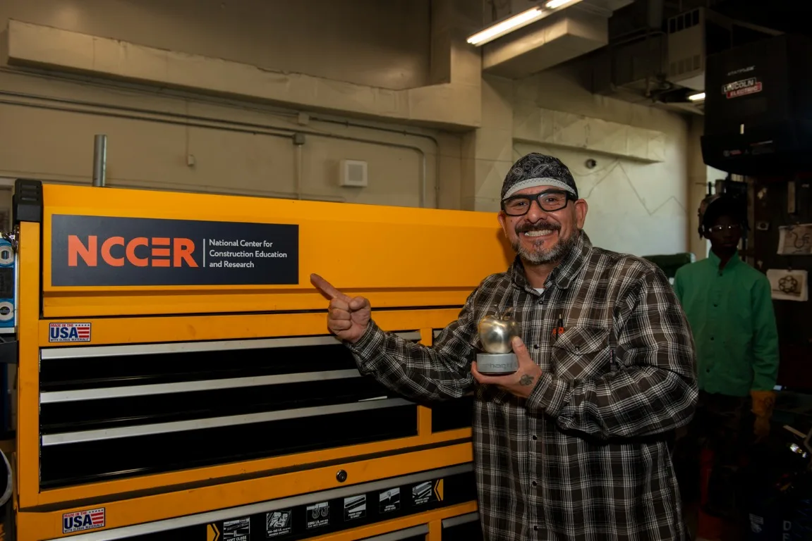 Steel Apple winner Josh O’Neal with a National Center for Construction Education and Research (NCCER) sign
