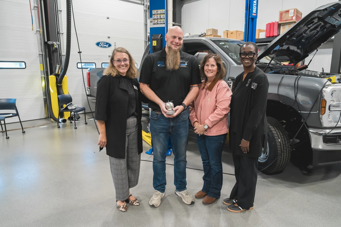 Kris Young being presented the Steel Apple Award by Carhartt CEO Linda Hubbard, TechForce COO Jennifer Bergeron, and Henry Ford College dean Dr. Patricia Chatman