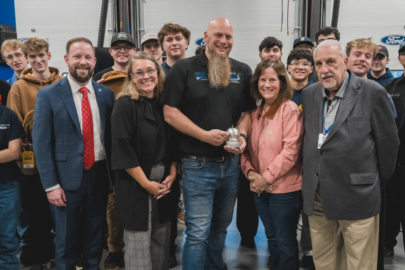 Steel Apple winner Kris Young with his Henry Ford College students and colleague, Carhartt CEO Linda Hubbard, and TechForce COO Jennifer Bergeron