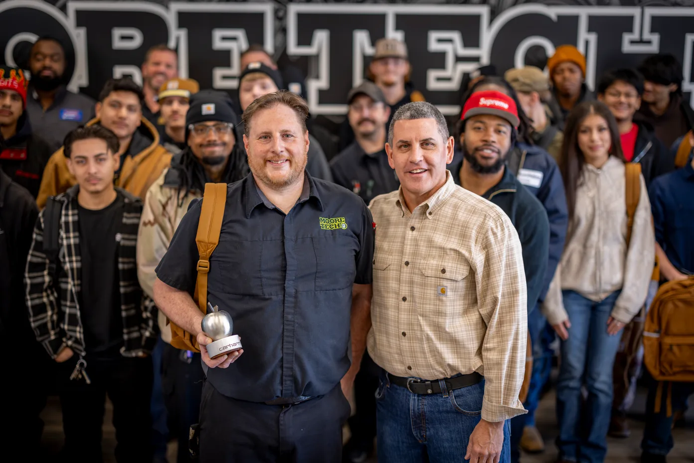 Steel Apple honoree Paul Frye with William Hardy, SVP of Supply Chain at Carhartt, and Moore Tech students